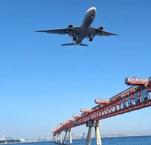 羽田空港付近の海でジェット機を見上げる風景